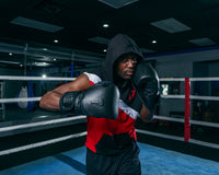 variant:lifestyle::TITLE Black Heavy Bag Gloves 2.0 left hand up boxing pose