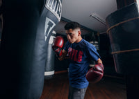 variant:lifestyle::TITLE Boxing Blood Red Leather Training Gloves kid hitting bag left hook