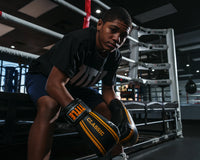 variant:black/gold::TITLE Classic Speed Boxing Gloves kid sitting on edge of ring