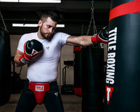 variant:lifestyle::TITLE Classic Groin Protector Plus 2.0 guy hitting bag