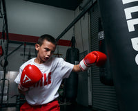 variant:red/white/black::TITLE Classic Leather Super Bag Gloves 2.0 kid hitting bag left jab