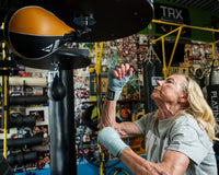 variant:Light Blue::TITLE Boxing Fight Back Semi-Elastic Hand Wraps hitting speed bag