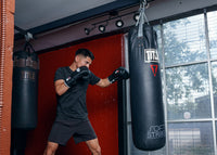 variant:black::Fighting Fury Professional Lace Training Gloves guy hitting bag