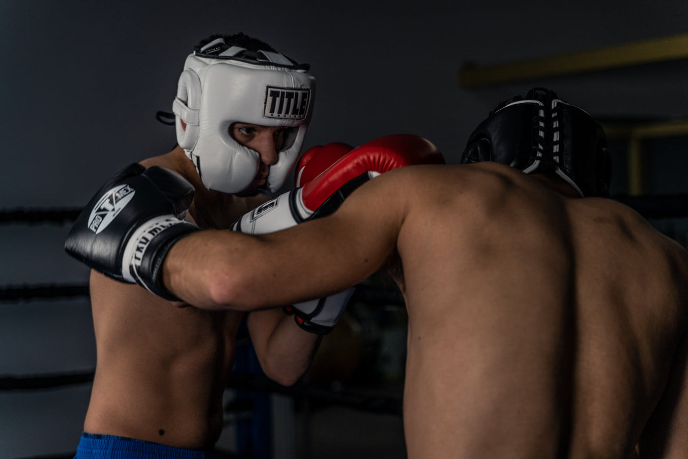 variant:White::TITLE Boxing Leather Sparring Headgear man wearing headgear sparring with another man
