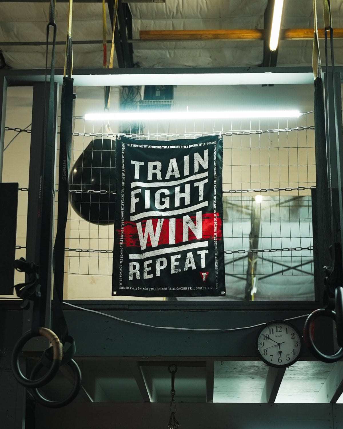 variant:lifestyle::TITLE Boxing Train Fight Win Repeat Banner on wall of boxing gym