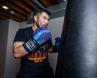 variant:lifestyle::TITLE Boxing Infused Electric Bag Gloves Rudy boxing stance with bag