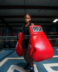 variant:red::TITLE Boxing Jumbo Boxing Gloves 2.0 kid posing with jumbo boxing gloves