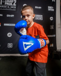 variant:blue/black/white::TITLE Classic Kid & Youth Boxing Gloves 2.0 kid posing with boxing gloves