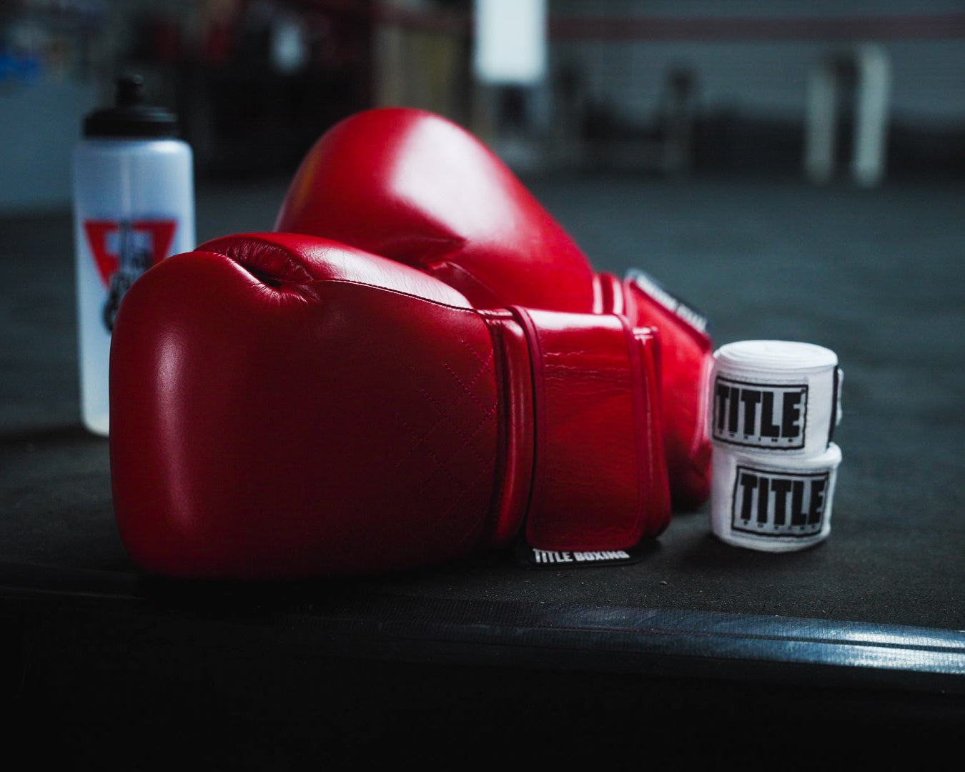 variant:red::TITLE Boxing Ko-Vert Bag Boxing Gloves sitting on side of boxing ring