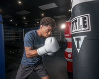 variant:white::TITLE Boxing Ko-Vert Bag Gloves guy wearing boxing gloves boxing with heavy bag