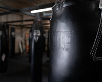 variant:black::TITLE Boxing KO-Vert Heavy Bag closeup of bag hanging in the gym