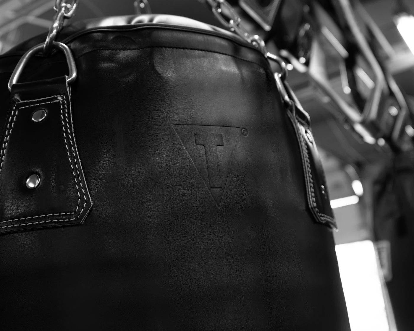 variant:black::TITLE Boxing KO-Vert Heavy Bag closeup of top of bag hanging in the gym