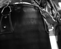 variant:black::TITLE Boxing KO-Vert Heavy Bag closeup of top of bag hanging in the gym