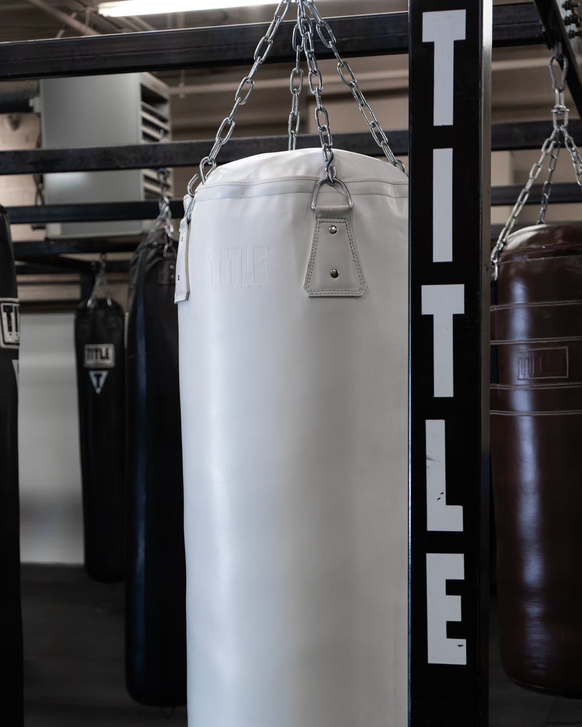 variant:white::TITLE Boxing KO-Vert Heavy Bag hanging in the gym