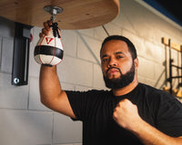 variant:lifestyle::TITLE Boxing Lightning Fast Speed Bag with boxer holding bag