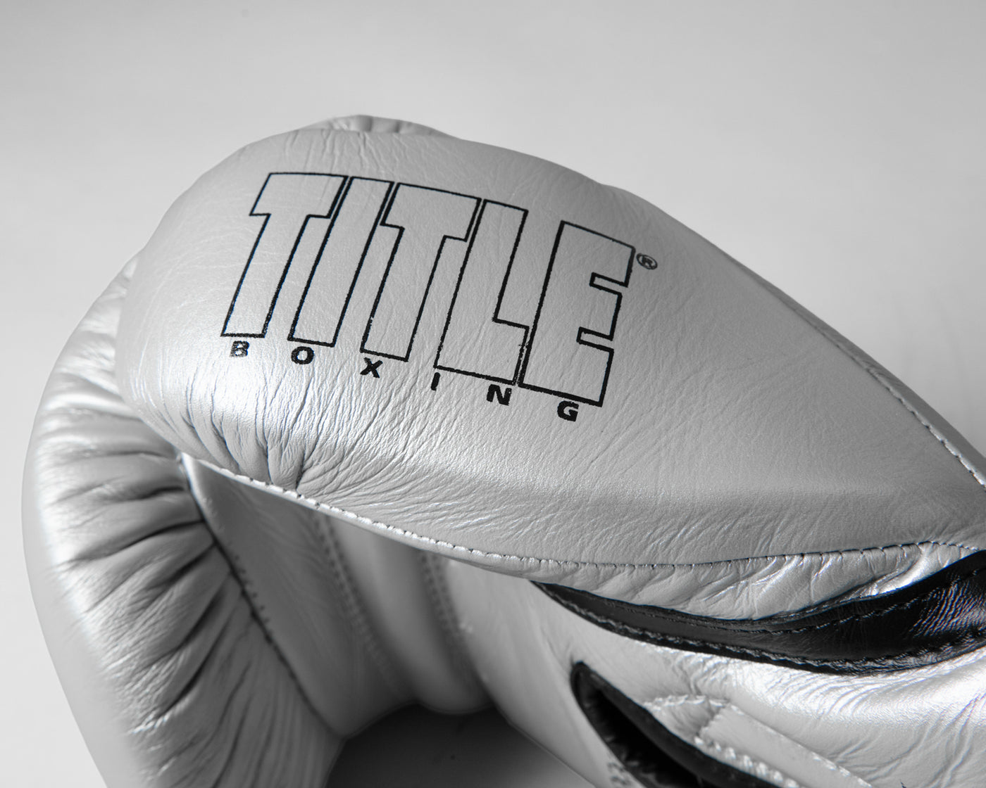 variant:silver/black::TITLE Boxing Momentum Pro Bag Gloves closeup of logo on thumb