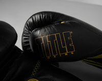 variant:black/gold::TITLE Boxing Momentum Pro Training Gloves closeup of logo on thumb