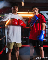 variant:blue/silver::TITLE Boxing Momentum Pro Training Gloves on boxers hands next to other boxer in ring