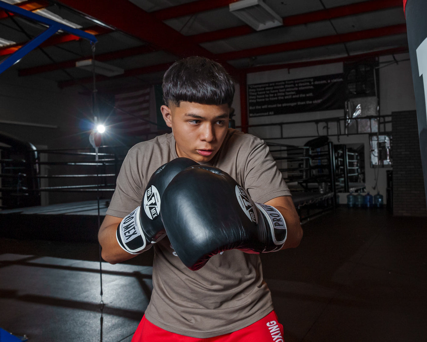 variant:black::Pro Mex Professional Training Gloves 3.0 kid swinging on bag
