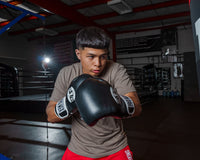 variant:black::Pro Mex Professional Training Gloves 3.0 kid swinging on bag