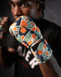 variant:hawaiian::TITLE Boxing Print Mexican Style 180" Hand Wraps on boxer's hands in fighting stance closeup