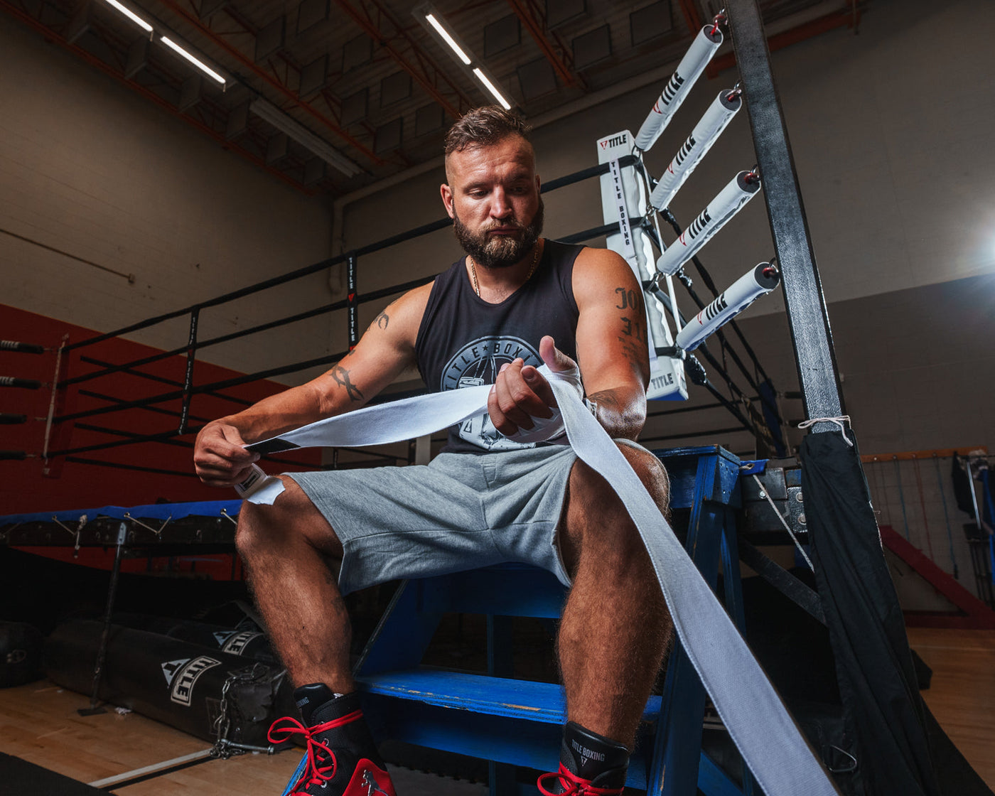 variant:white::TITLE Boxing Select 180" Semi Elastic Mexican Hand Wraps guy unrolling wrap
