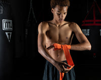 variant:orange::TITLE Boxing Select 180" Semi Elastic Mexican Hand Wraps guy puttin gon wrap 