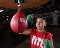 variant:green::TITLE Boxing Select 180" Semi Elastic Mexican Hand Wraps girl hitting a speed bag