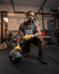variant:12 lbs::TITLE Boxing Rubber Medicine Ball kid kneeling down with ball
