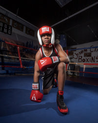 variant:black/red::TITLE Charged Boxing Shoes kid kneeling with shoes on