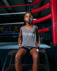 variable:Grey::TITLE Boxing Women's Ogio Luuma Tank girl posing sitting on boxing ring