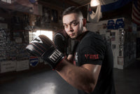 variant:lifestyle::TITLE Boxing Heavy Bag & Mitt Bundle gloves on boxer in the gym