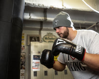 variant:lifestyle::TITLE Boxing Heavy Bag & Mitt Bundle gloves on boxer in the gym
