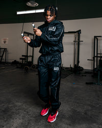 variant:lifestyle::TITLE Boxing Sauna Suit With Hood guy wearing sauna suit jumping rope