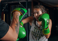 variant:Green/Black::WBC by TITLE Boxing Bag Gloves man wearing gloves mitting with coach