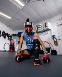 variant:lifestyle::TITLE MMA Command Training Headgear girl sitting on ground