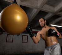 variant:black::TITLE Classic Leather Elastic Training Gloves 2.0 Media 1 of 21 guy hitting water bag