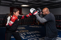 variant:lifestyle::TITLE Boxing Gel World Contoured Punch Mitts girl and coach