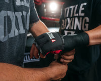 variant:lifestyle::TITLE Boxing Gel Iron Fist Slip-On Knuckle Shields 2.0 man getting hands wrapped