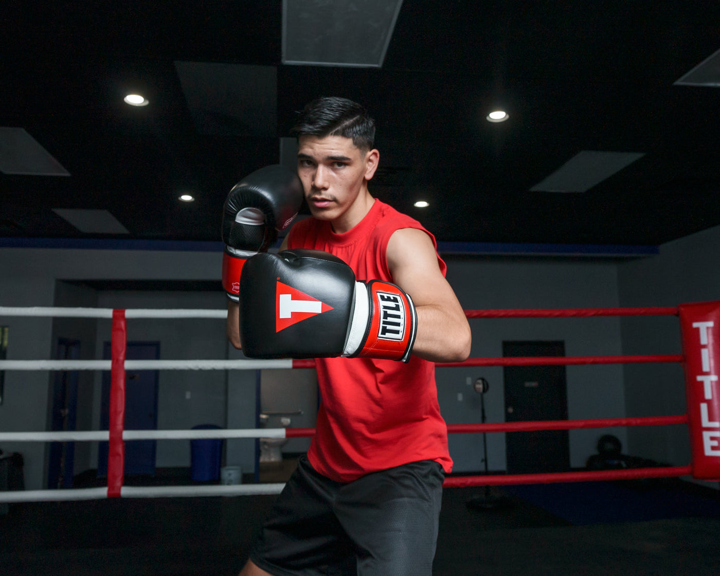 variant:Black/White/Red::TITLE Boxing Gel Weighted Boxing Gloves person posing with boxing gloves in gym