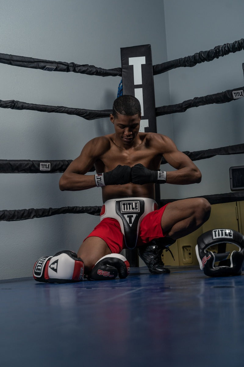 variant:lifestyle::TITLE Boxing Gel Iron Fist Wraps guy sitting in ring