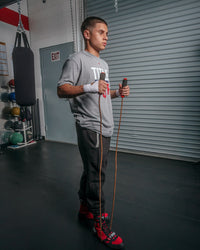 variant:lifestyle::TITLE Classic Leather Speed Rope 2.0 guy holding jump rope underneath foot